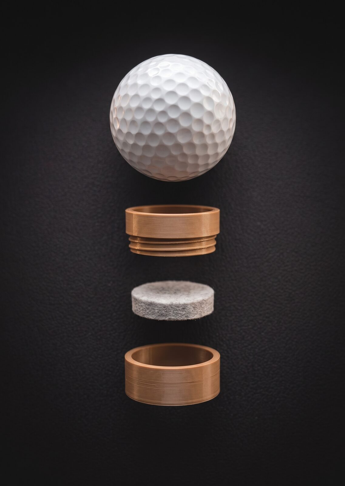 Exploded view of the Dimple¹ stamp: rescued golf ball, threaded wood-toned PLA housing, stamp pad and screw-on cap