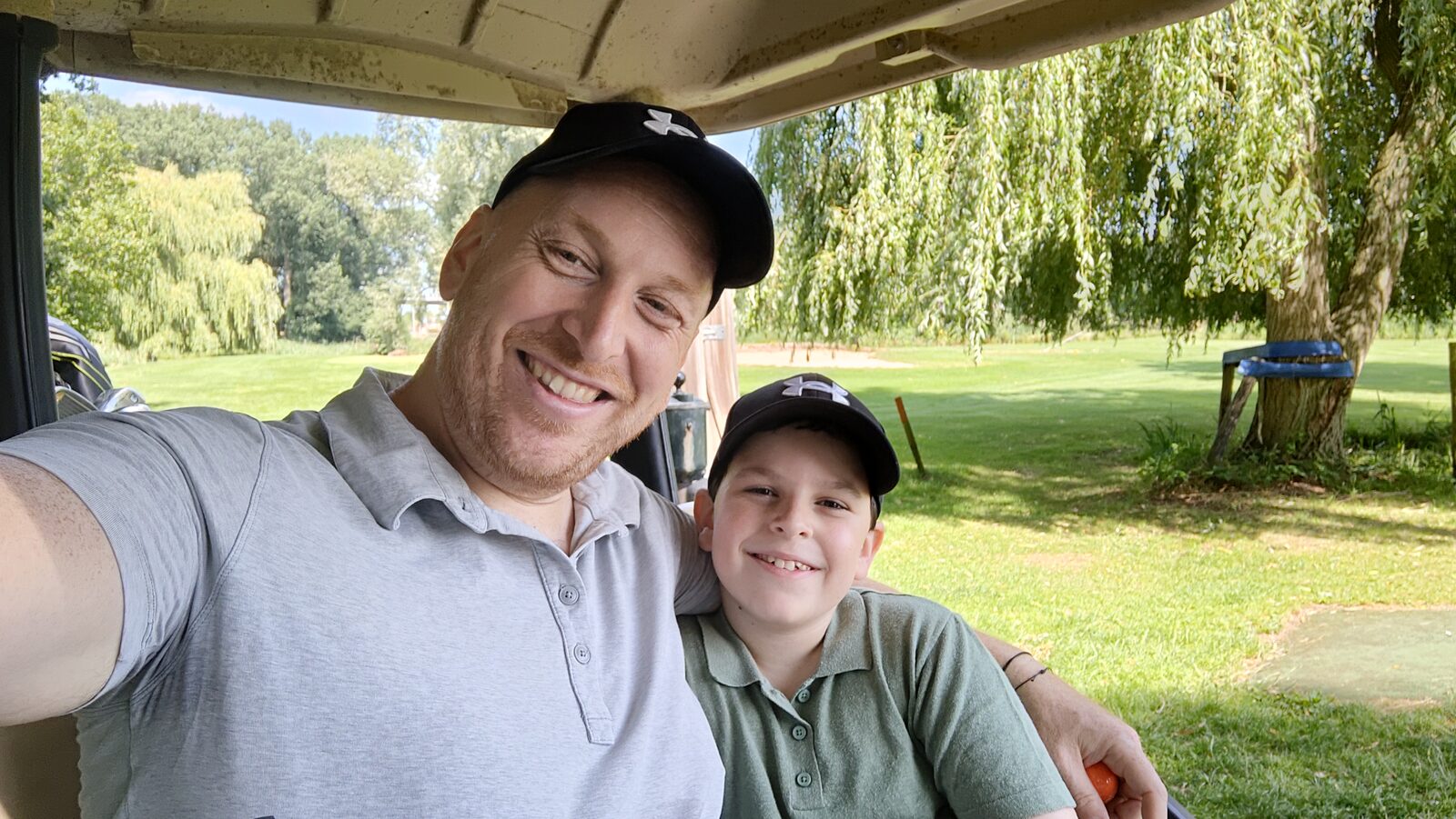 Founder and his son together on a golf course, both wearing golf caps